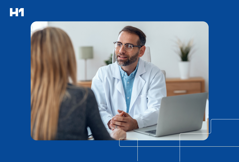 doctor sitting at a computer speaking with patient